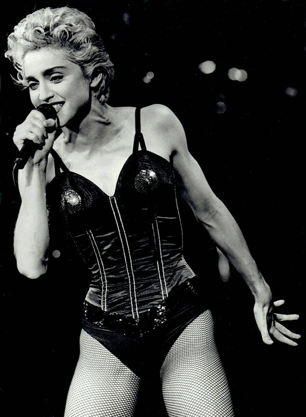 Madonna performs in 1987 wearing a black structured bodice and fishnet tights.